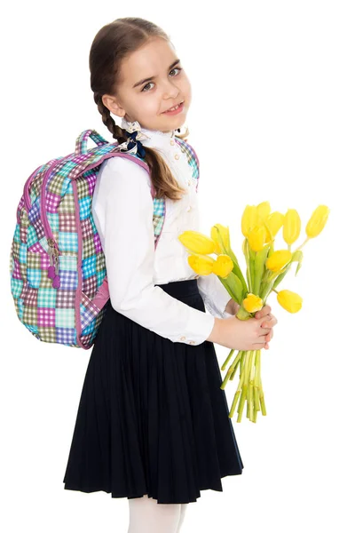 Una colegiala con un ramo de flores y una mochila en su sho —  Fotos de Stock