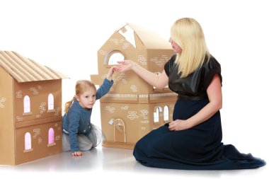 Kızı ve annesi karton evden çevresinde oynamak.