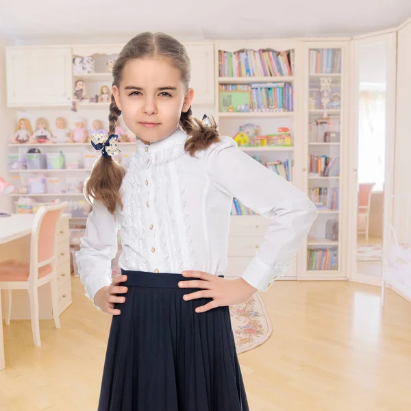 Ένα μικρό κορίτσι σε ένα λευκό φόρεμα και μια σκούρα φούστα. — Φωτογραφία Αρχείου