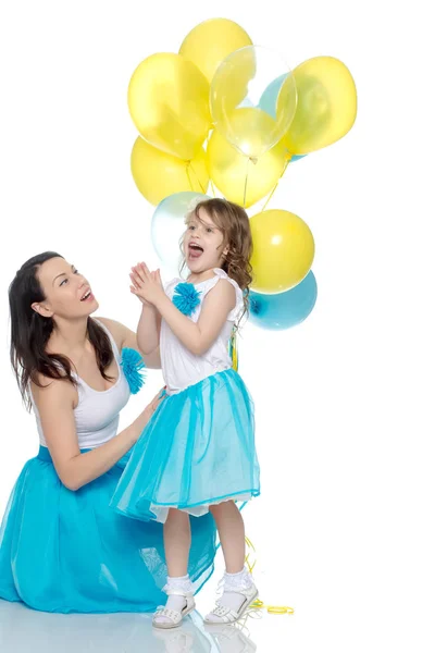 Mutter und Tochter mit bunten Luftballons. — Stockfoto