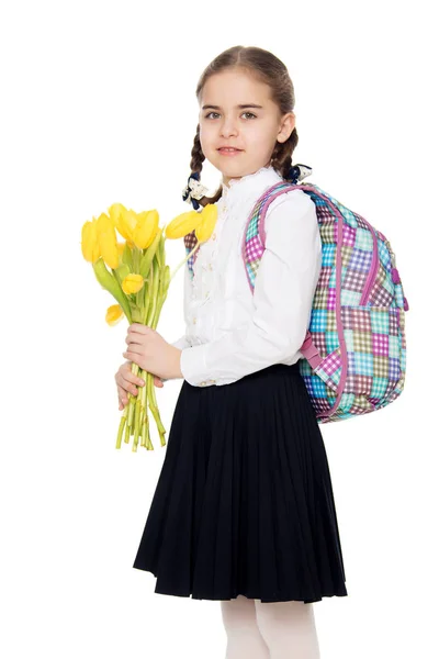 Школярка з букетом квітів і рюкзаком на її черевику — стокове фото