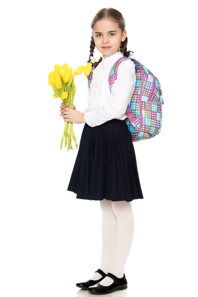 Школярка з букетом квітів і рюкзаком на її черевику — стокове фото