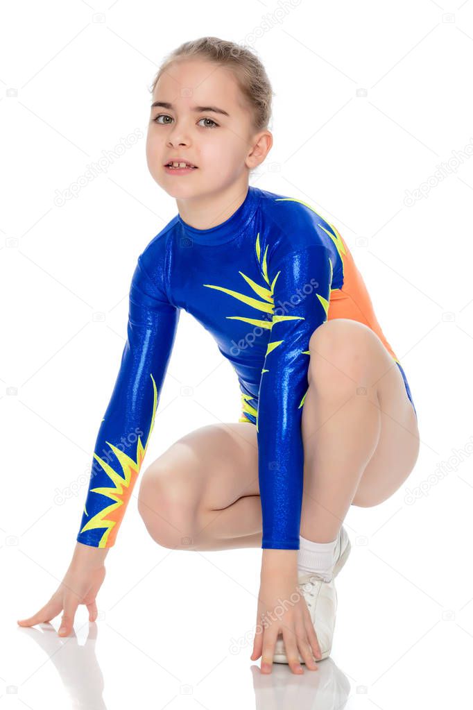 Beautiful little girl gymnast is squatting.