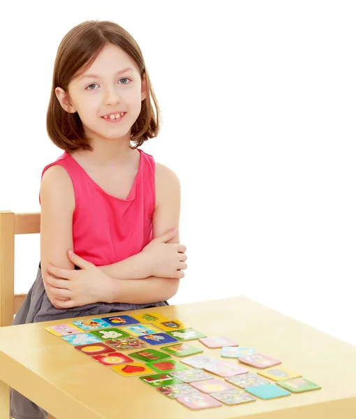 Malá holka položí karty na stůl — Stock fotografie