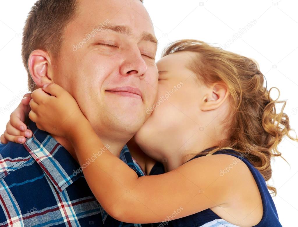 Little girl kissing dad.