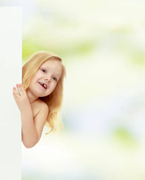 Ein kleines Mädchen lugt hinter dem Banner hervor. — Stockfoto