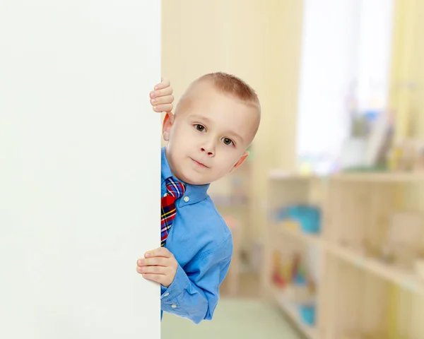 Boy peeks out from behind the banner — Stock Photo, Image