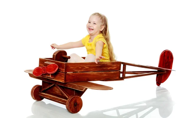 Menina está montando um avião de brinquedo . — Fotografia de Stock