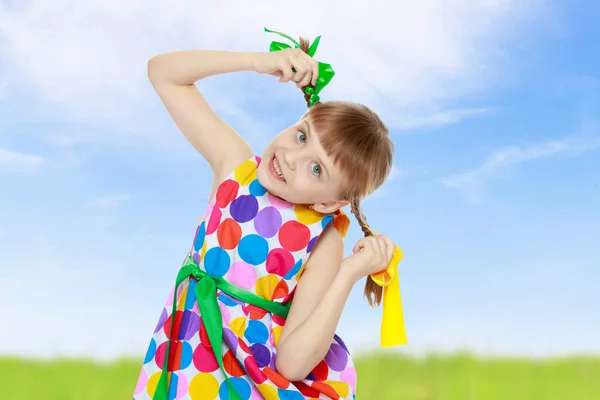 A little girl in a dress with a pattern from multi-colored circl — Stock Photo, Image