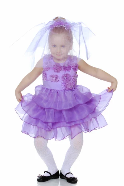 Klein meisje in paarse jurk. — Stockfoto