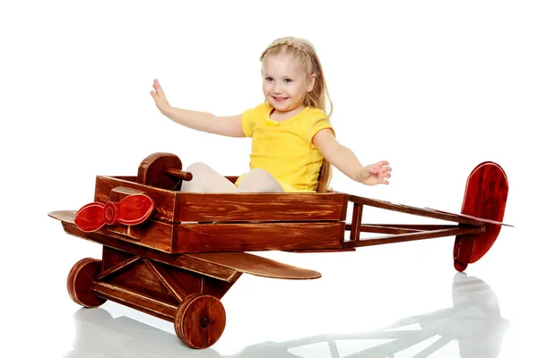 Menina está montando um avião de brinquedo . — Fotografia de Stock