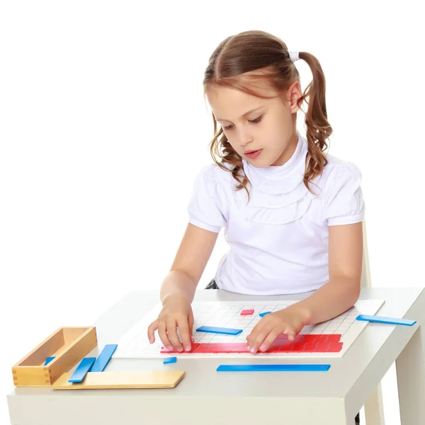 A little girl is studying Montessori stuff. — Stock Photo, Image