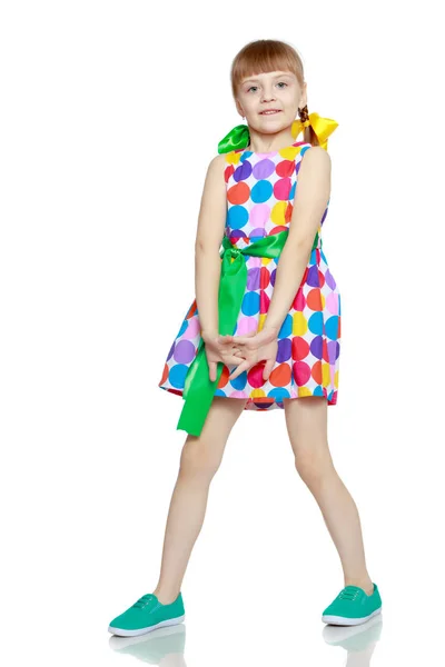 Çok renkli circl üzerinden bir desenli elbise giymiş küçük bir kız — Stok fotoğraf