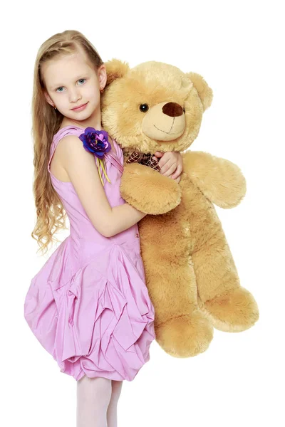 5-6 yıl güzel küçük bir kız. O büyük bir oyuncak ayı tutuyor bea — Stok fotoğraf