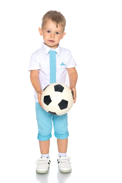 Um menino está brincando com uma bola . — Fotografia de Stock