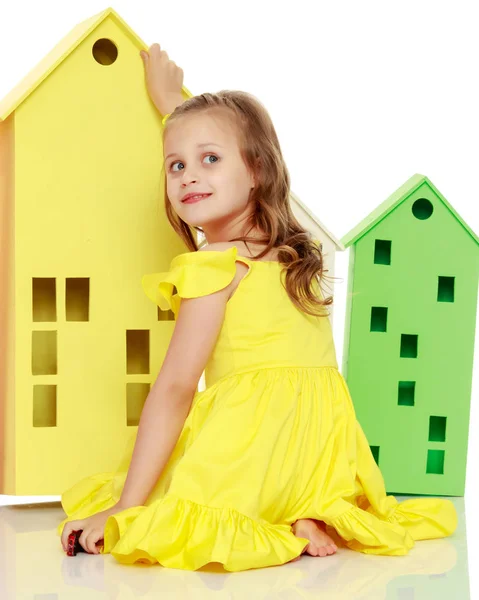 Little girl is playing with wooden houses. — Stock Photo, Image