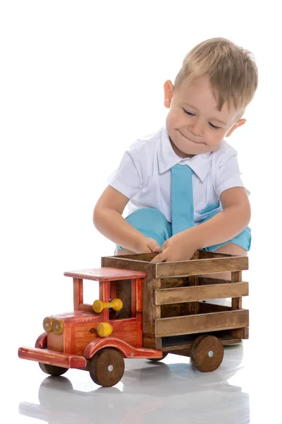A little boy is playing with a toy car. — Stock Photo, Image