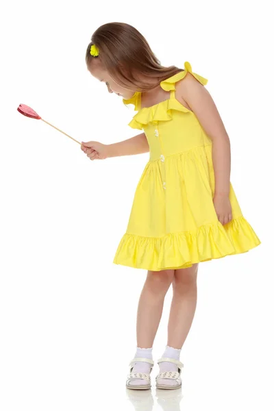 Little girl with a candy on a stick — Stock Photo, Image