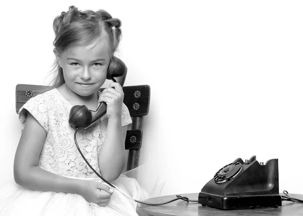 A little girl is ringing on the old phone. — Stock Photo, Image