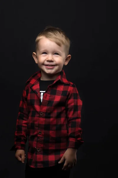 Kleine jongen op een zwarte achtergrond. — Stockfoto