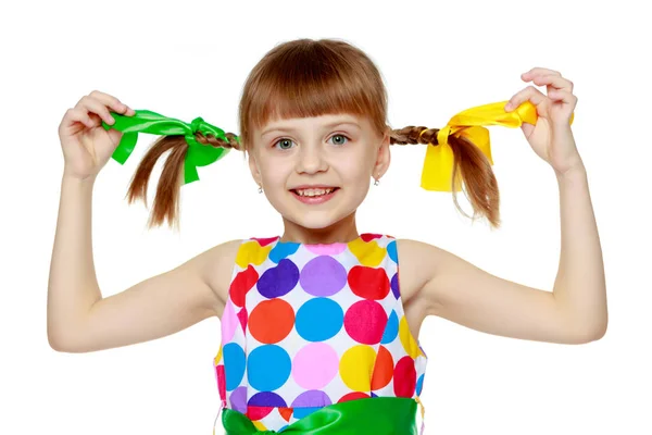 Une petite fille dans une robe avec un motif de cirque multicolore Images De Stock Libres De Droits