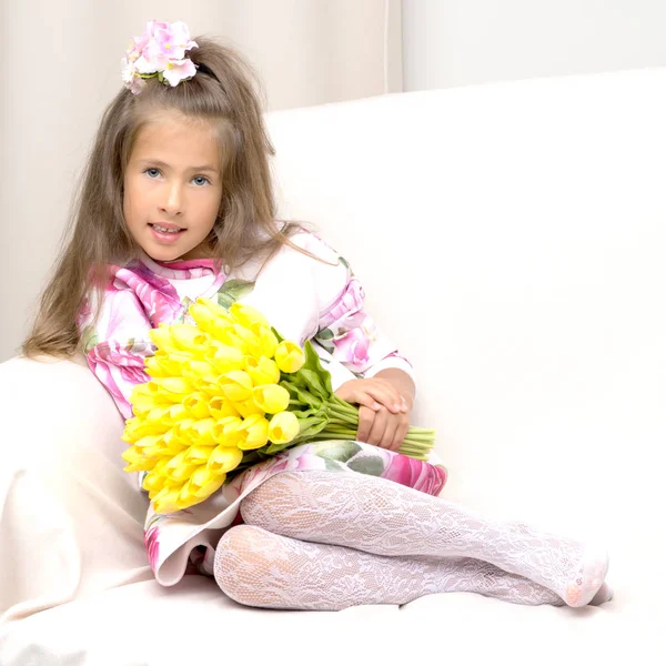 Klein meisje met een boeket bloemen — Stockfoto