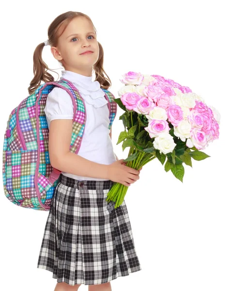 Mała dziewczynka uczennica z kwiatami — Zdjęcie stockowe