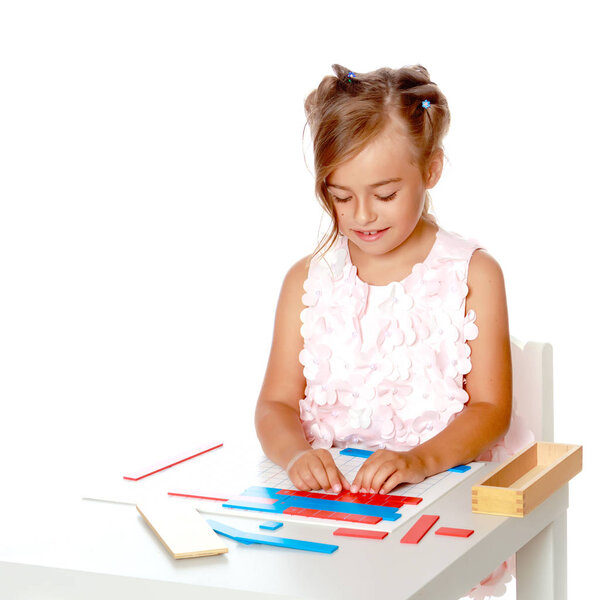 Маленькая девочка изучает вещи Монтессори..