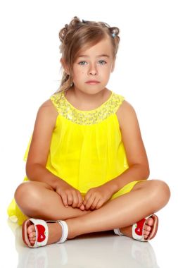 Küçük kız yerde oturuyor..