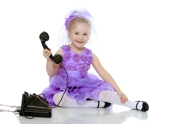 The girl is talking on the old phone. — Stock Photo, Image
