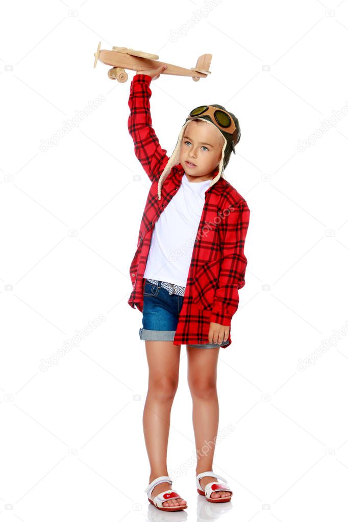 Little girl with a wooden plane in her hand.