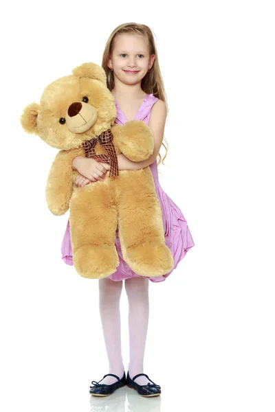 Belle petite fille 5-6 ans.Elle tient un grand bea en peluche — Photo