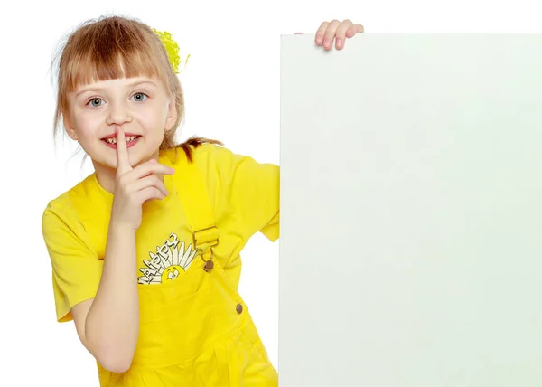 Girl with a short bangs on her head and bright yellow overalls. — Stock Photo, Image