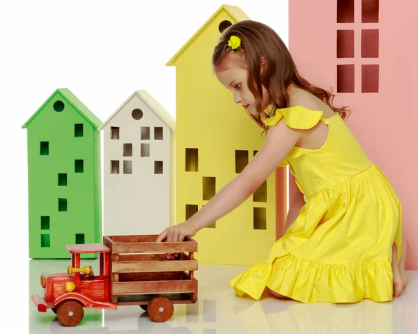 Malá holčička hraje s dřevěné auto. — Stock fotografie