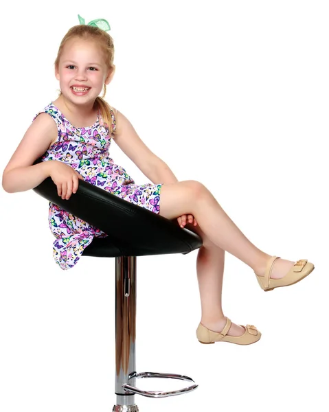 Küçük kız bir sandalyede oturuyor — Stok fotoğraf