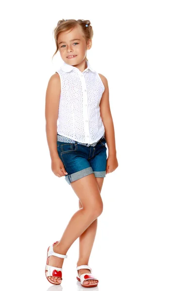 Una bambina in pantaloncini e una camicia bianca . — Foto Stock