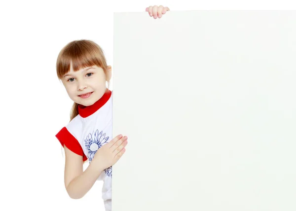 Una bambina sta guardando da dietro uno striscione vuoto. — Foto Stock