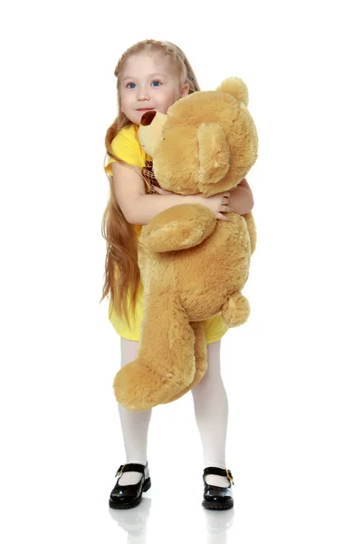 Kız büyük bir oyuncak ayı hugs. — Stok fotoğraf