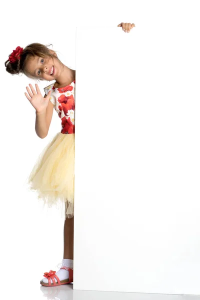 A little girl is looking from behind an empty banner. — Stock Photo, Image