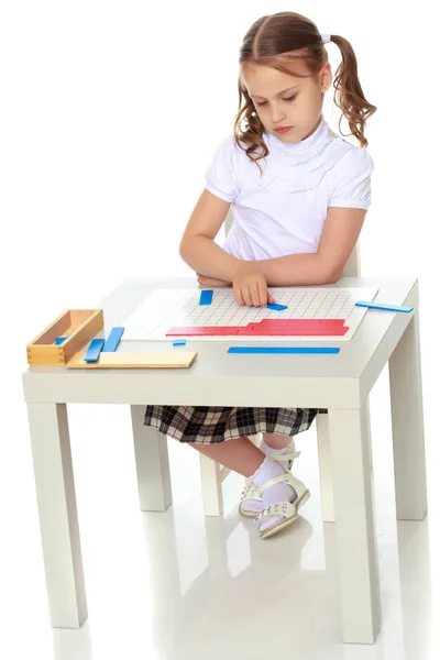 A little girl is studying Montessori stuff. — Stock Photo, Image