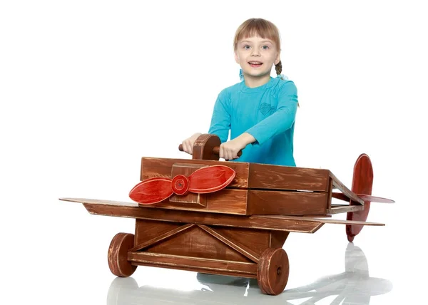 A menina está brincando com um avião de brinquedo grande . — Fotografia de Stock