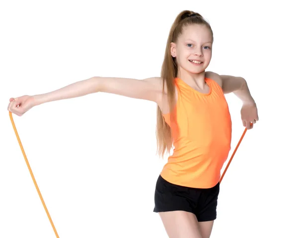 En flicka gymnast utför övningar med ett hopprep. — Stockfoto