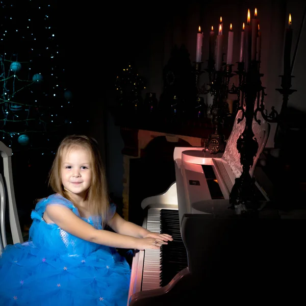 Bambina suona il pianoforte a lume di candela. — Foto Stock
