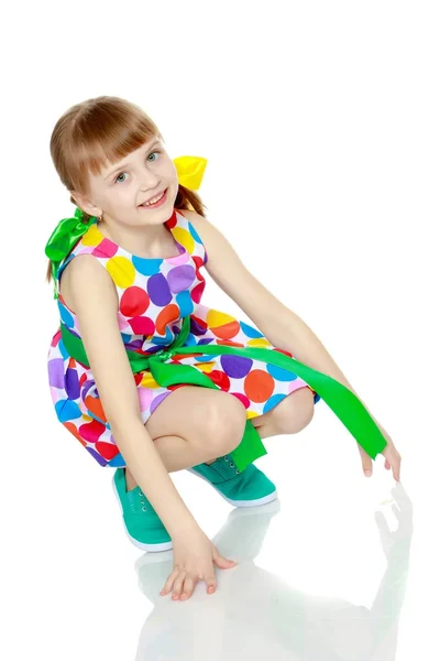 Una niña en un vestido con un patrón de circl multicolor — Foto de Stock