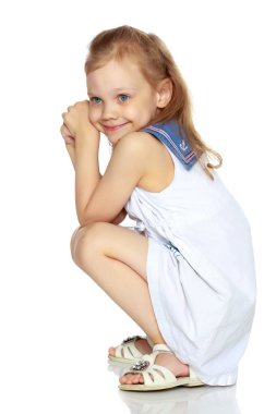 Küçük kız yerde oturuyor..