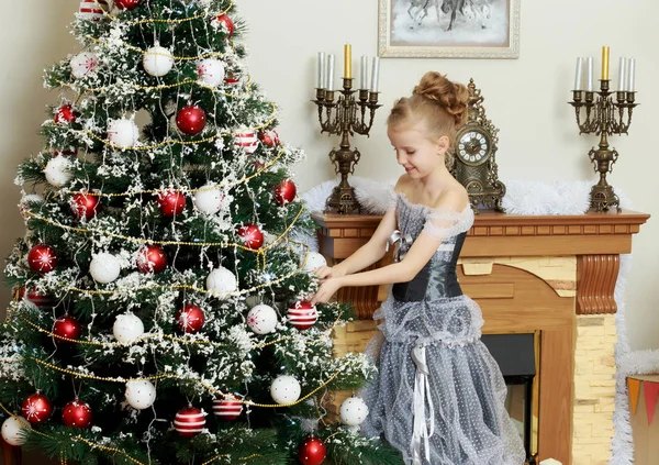 Little girl decorates the Christmas tree . — Stock Photo, Image