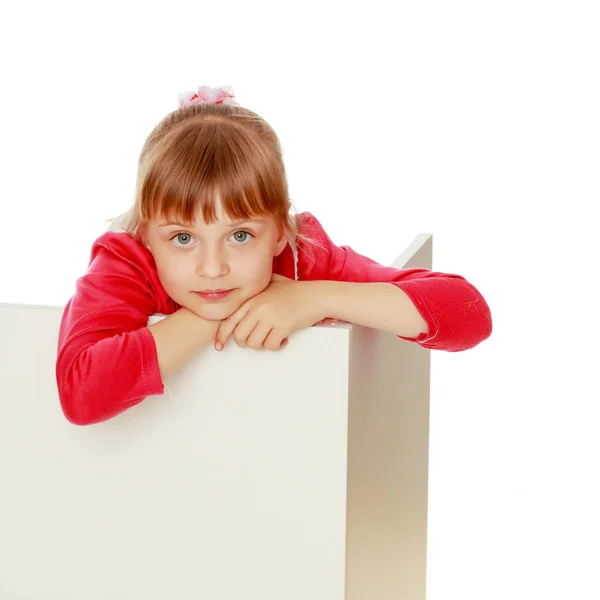 En liten flicka tittar bakom en tom fana.. — Stockfoto