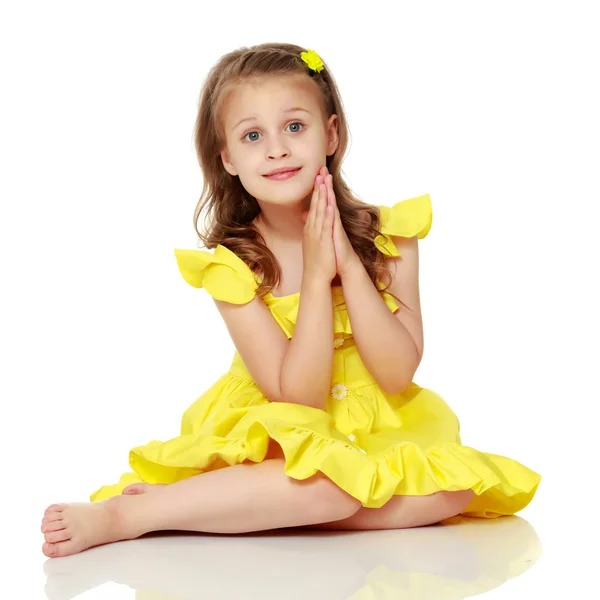 Little girl is sitting on the floor. Royalty Free Stock Images