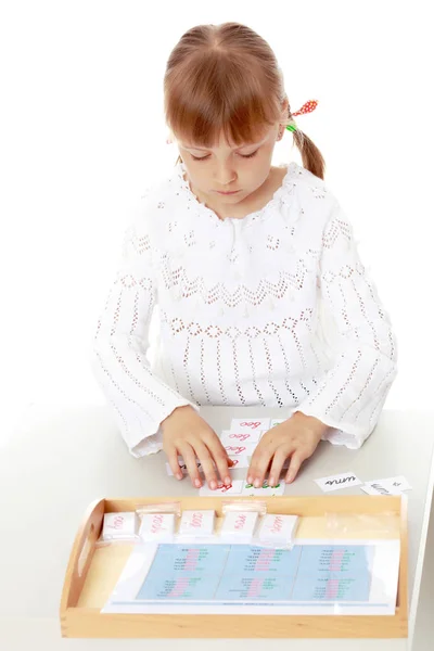 Een klein meisje studeert Montessori dingen.. — Stockfoto