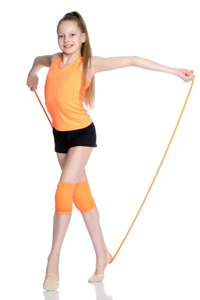 Uma ginasta executa exercícios com uma corda pulando. — Fotografia de Stock